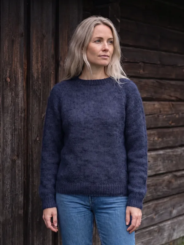 Alpakkagenser i fargen Fjord, brukt av en kvinne