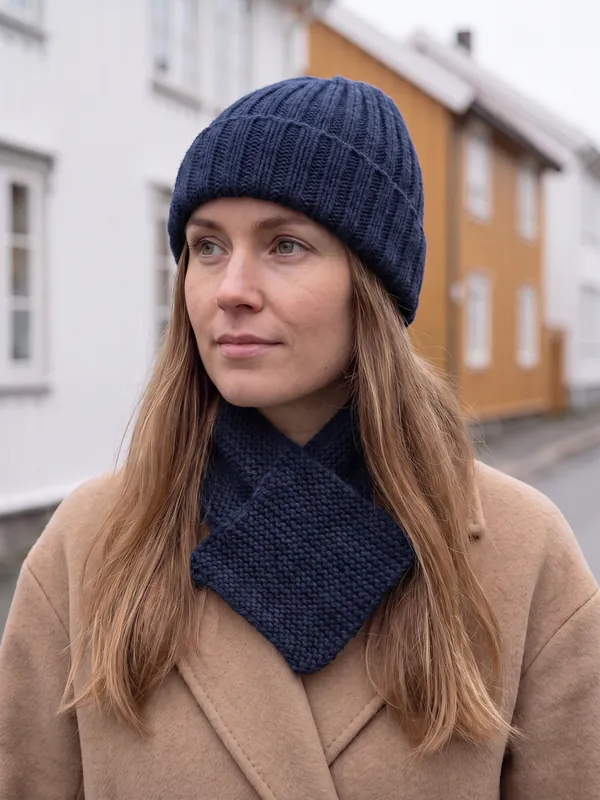 Skjerf og lue i fargen Fjord, brukt av en kvinne